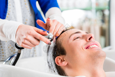 在美发店洗男人头发的女发型师背景图片