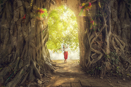 美丽的少女泰国舞蹈艺术与太阳光线在深林中的奇幻场景图片
