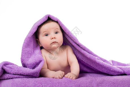 刚出生的婴儿躺在紫色的毛巾里微笑着图片