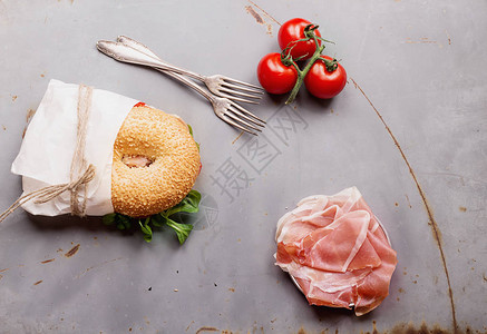 意大利香肠奶油乳酪西红柿和沙拉的百吉饼图片