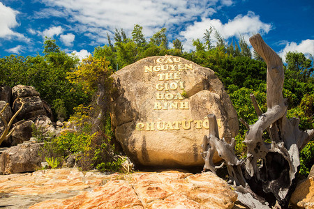 越南NhaTrang市附近海面上的HonDo岛的风景云天空和橙状岩石以及带有象形字的小塔振背景