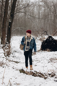 时髦的潮流旅行者背着红色帽子的背包在冬图片