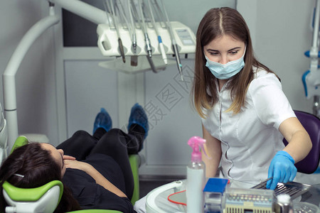 牙医在牙科诊所准备检查女牙齿的仪器图片