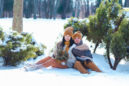 女孩和男孩欧洲外观在冬天的白雪中拥抱图片