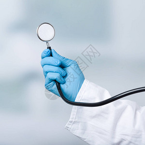 手持套的医生拿着听诊器图片
