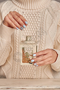 针织毛衣上带有水钻的嫩蓝色修指甲圣诞美甲理念寒假风格明亮的修指甲设计背景图片