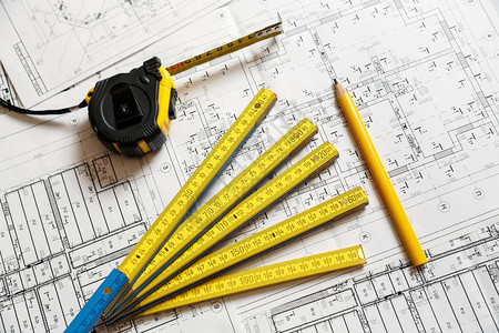 带尺子的卷尺黄色铅笔和可折叠尺子在建筑蓝图计划上的图像建图片