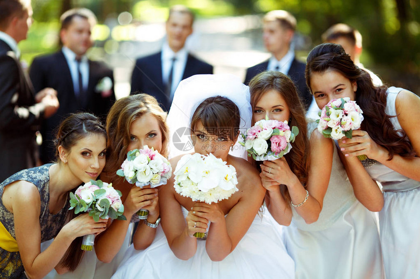 女孩和新娘拿着婚礼花束摆姿势新郎和伴图片
