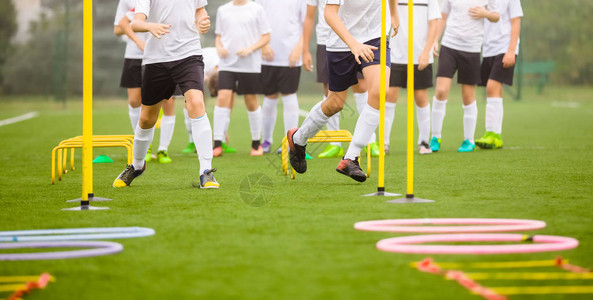 足球技能培训课程球员在球场上训练足球障碍课程草足球场教练足球装备设图片
