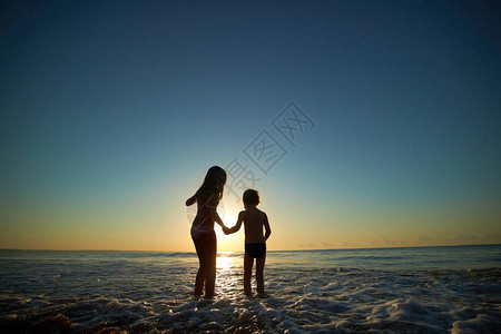 夕阳下海上的男孩和女孩图片