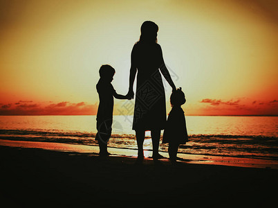 母亲和两个小孩在日落时图片