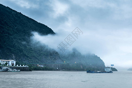 在长江上旅行观望山丘和城镇高清图片