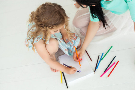 小可爱的女儿和她的母亲用彩色铅笔画背景图片