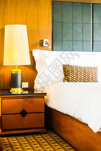 床上漂亮的豪华白色枕头和酒店卧室内部装饰旁边的灯图片