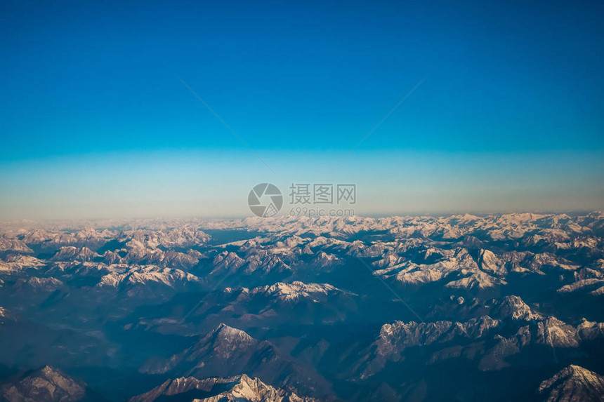 在飞行过程中透过窗户飞机看雪覆盖的意大利和奥斯特赖希阿尔卑斯图片