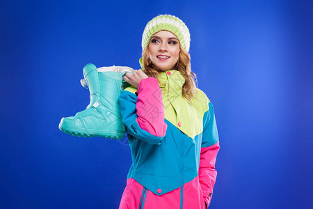 身穿滑雪西装穿着滑雪靴蓝背景图片
