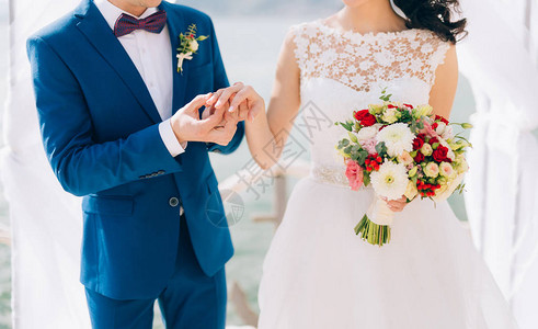 新郎新娘在婚礼的手指穿裙子一枚戒指图片