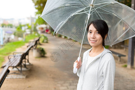 拿着雨伞微笑的女人图片