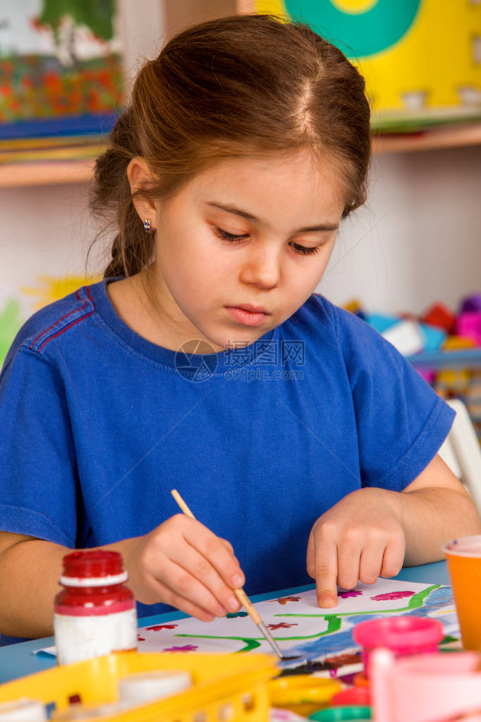 小学生女孩在艺术学校课上绘画孩子在桌子上用颜料画女孩集中绘图工艺绘画教育培养孩图片