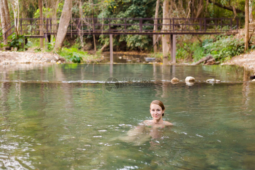 年轻的白种人美女游客在泰国北部丛林中隐藏的PaiSaiNgam秘密温泉享受沐浴在夏季图片
