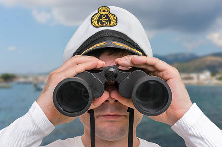 船长通过双筒望远镜观察海洋概念图片