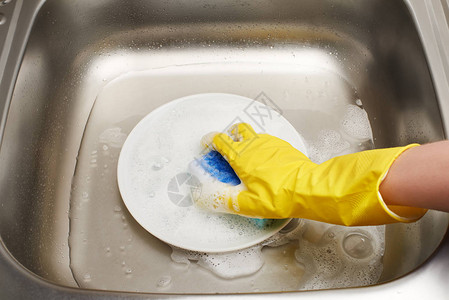 黄色防护橡胶手套洗白板与蓝色清洁海绵对厨房水图片