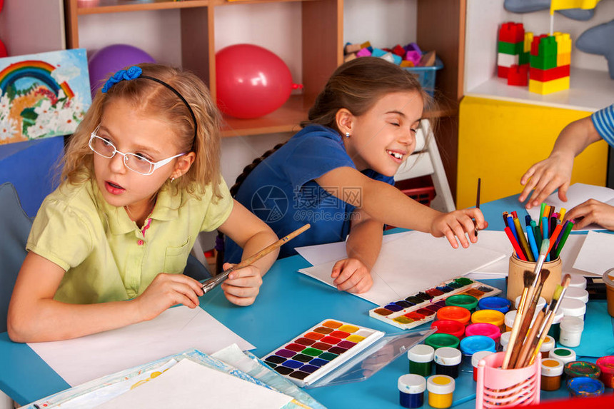 小学生在艺术学校课上画孩子在桌子上用颜料画气球背景上的孩子幼儿园女孩的顶视图绘画教育培养孩图片