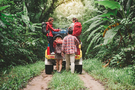 快乐的亚洲年轻旅行者在森林里开着四驱车越野背景图片