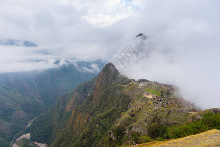 马丘比被从开放的云层中射出的第一缕阳光照亮印加人的城市是秘鲁访问量最大的旅游目的地雾背景图片
