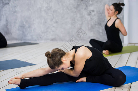年轻女在瑜伽课前热身的镜头年轻人坐在瑜伽课图片
