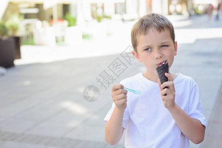 快乐的小男孩在市中心吃冰淇淋图片