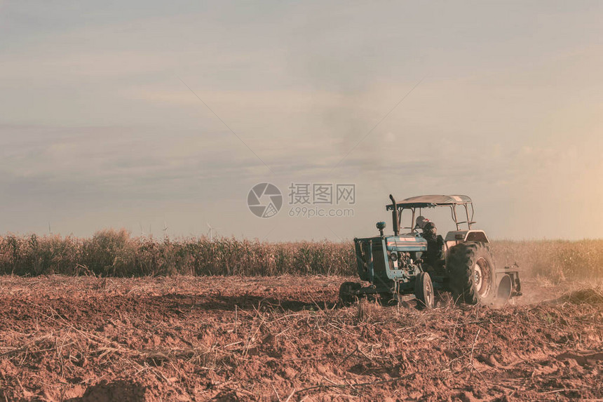 农民们正在使用拖拉机耕种旱田图片