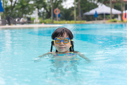 亚裔小女孩在游泳池背景图片