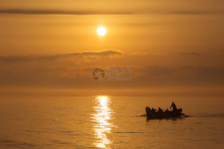 乘船在海上捕鱼的渔民背图片