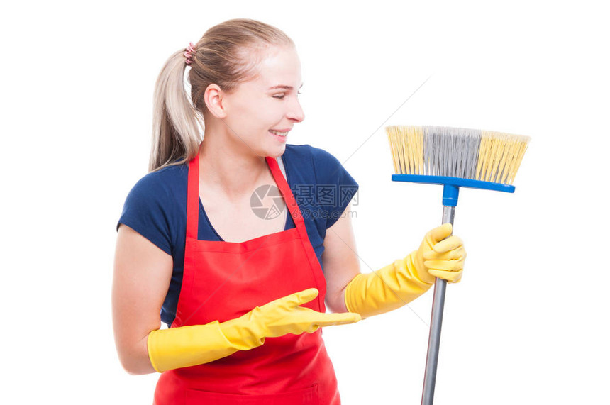 漂亮的女清洁女工展示她的扫把在白色