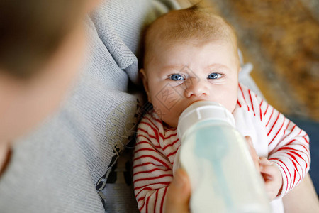 父亲用奶瓶里的牛奶喂养刚出生的小女儿婴儿配方奶粉新出生的孩子图片
