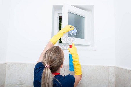 年轻妇女在家中擦小窗户做一般清洁图片