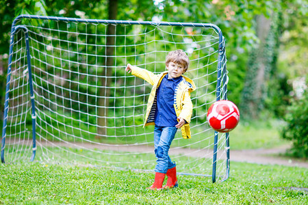活跃可爱的小男孩踢足球和足球图片