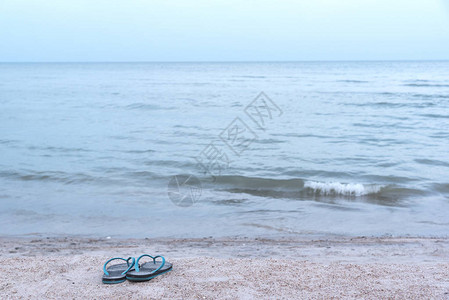 沙滩上的一双蓝色橡胶拖鞋图片