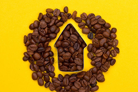黄色背景上箭头形状的咖啡豆背景图片