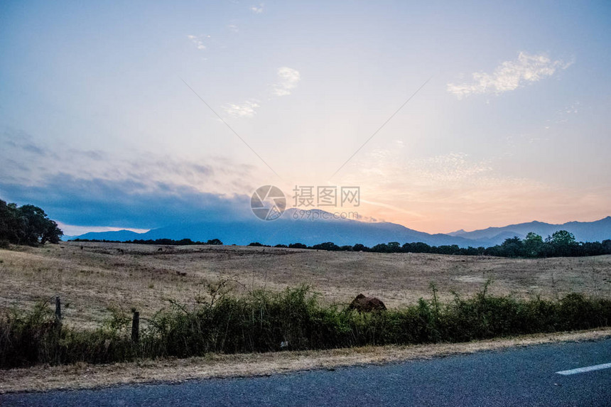 欧洲道路上自然元素的美丽日落与图片