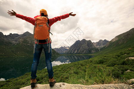 欢呼的年轻背包客在山上徒步旅行图片