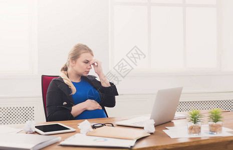 孕妇在办公室的笔记本电脑上工作图片