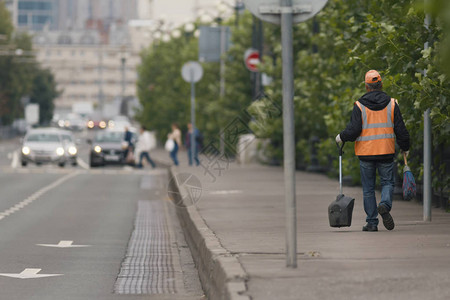 俄罗斯特大用扫帚工具沿城市街道行走的公路清图片