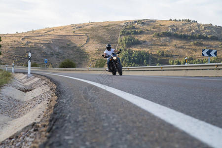 年轻人骑摩托车在路上在阳光明媚的一天翻山倒地图片