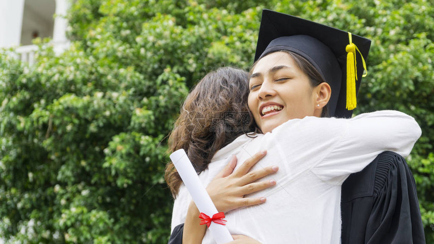 女学生的毕业服与帽子拥抱父在祝贺仪式图片