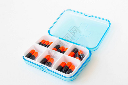 白色背景药盒中的药丸和胶囊图片