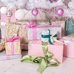 礼品盒粉色和白色圣诞装饰球挂在一棵装饰白色圣诞树上概念新年图片
