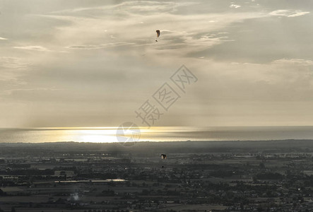 日落时两个滑翔伞的视图图片
