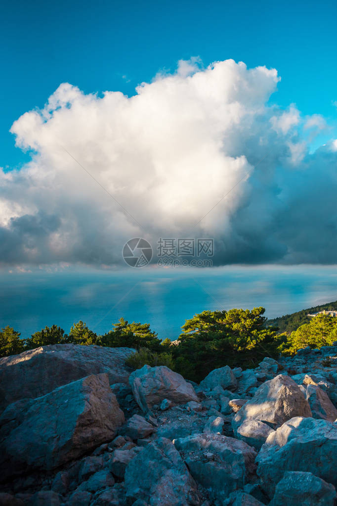 海岸和山脉美丽的海景反对天空的石山与云彩图片